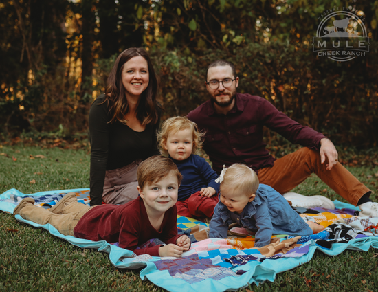 Bump family photo on picnic blanket at dusk with focal point and branded